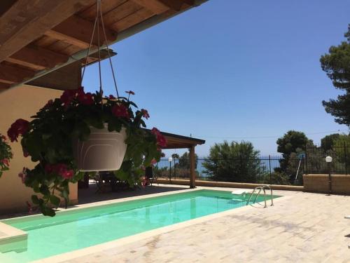 una piscina con una maceta al lado de una casa en Jolie villa avec piscine privée, en Porto Empedocle