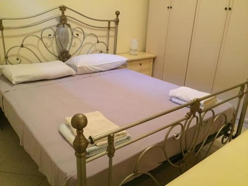 1 dormitorio con cama de metal con sábanas blancas en Jolie villa avec piscine privée, en Porto Empedocle