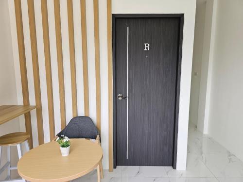 a room with a door with a table and a chair at Haru Inn Airport in Ban Bo Han