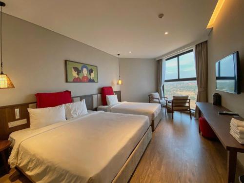 a hotel room with a large bed and a desk at APEC Mandala Mũi Né in Mui Ne