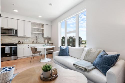 a white living room with a couch and a table at Downtown Luxury 1BD- Poo Spa Bowl Golf Gym Parkng in McIntyre Building Condominium