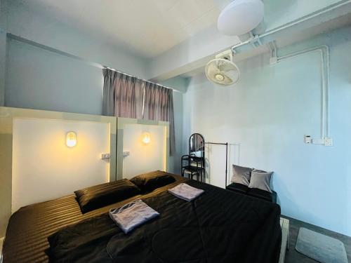 a bedroom with a large bed with black sheets at Patone Hostel in Phra Nakhon Si Ayutthaya
