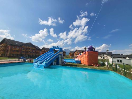 a blue water slide in a swimming pool at Apartmán Andrea Tatragolf in Veľká Lomnica