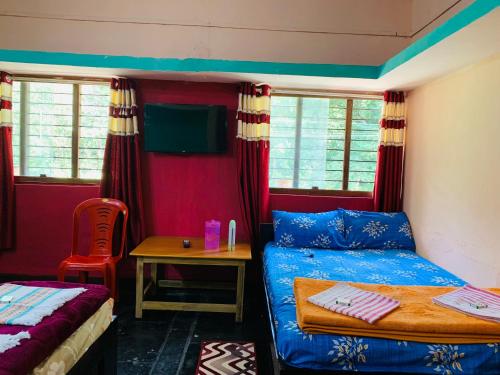 a bedroom with a bed and a table with a chair at Dandeli Crocodile Valley Homestay in Dandeli
