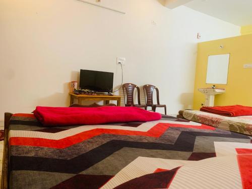 a room with two beds and a desk with a computer at Dandeli Crocodile Valley Homestay in Dandeli