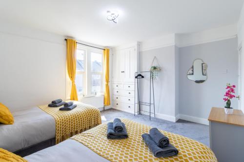 a bedroom with two beds and a window at Open Mind Property - Cosy Home - 7 Beds & Parking in Portsmouth