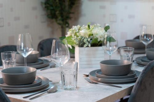 a table with plates and wine glasses on it at Open Mind Property - Cosy Home - 7 Beds & Parking in Portsmouth