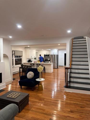 a living room with a staircase and a man in a kitchen at 4 bed Luxury house in Schenectady
