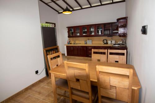 a kitchen with a wooden table and chairs at Green Villa Apartment in Unawatuna