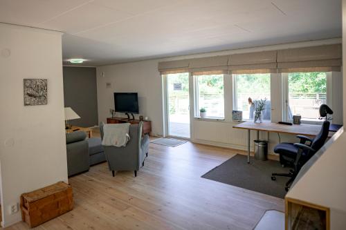 a living room with a couch and a desk and chairs at Sea-loving house in Åhus