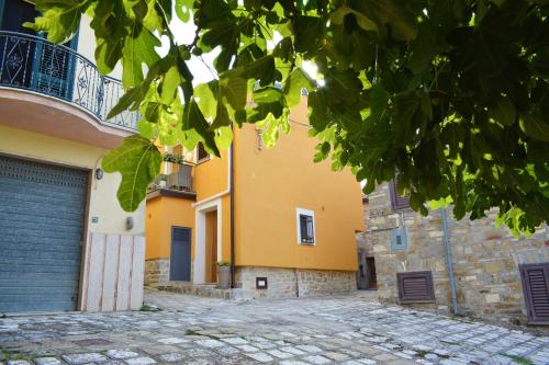 a yellow building with a gate and a driveway at CasArancio 6 in San Paolo Albanese