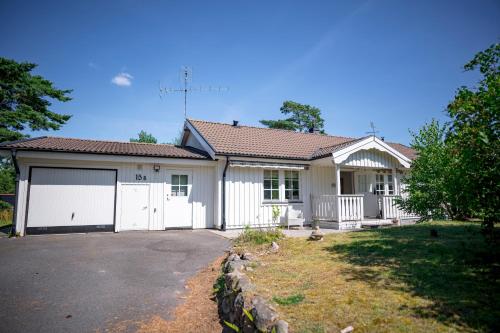 a large white house with a garage at Sea-loving house in Åhus