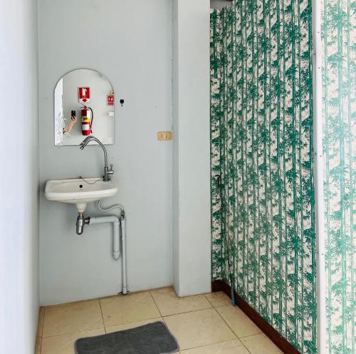 a bathroom with a sink and a shower curtain at Patone Hostel in Phra Nakhon Si Ayutthaya