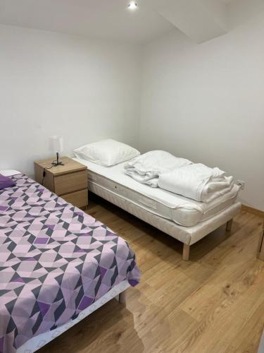 - une chambre dotée d'un lit avec des draps violets et blancs dans l'établissement Appartement 5 chambres dans le centre du village, à Pélussin