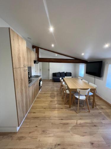 une cuisine et une salle à manger avec une table et des chaises dans l'établissement Appartement 5 chambres dans le centre du village, à Pélussin