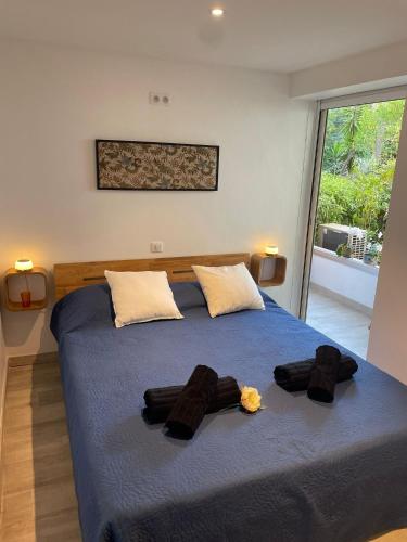 une chambre avec un lit bleu avec deux peignoirs dessus dans l'établissement Cannes, à Cannes