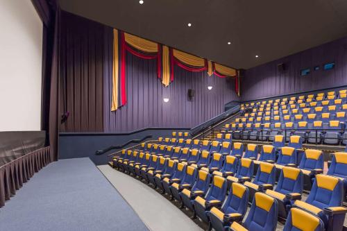 an auditorium with blue chairs and purple walls at Wyndham Gettysburg Hotel & Conference Center in Gettysburg