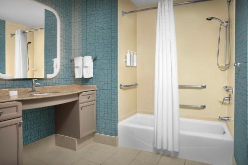 a bathroom with a tub and a sink and a shower at Homewood Suites by Hilton Irving-DFW Airport in Irving
