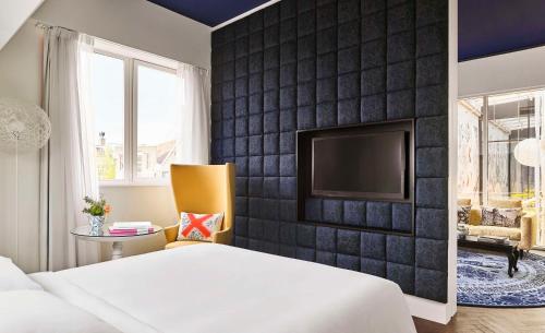 a bedroom with a black accent wall and a tv at Andaz Amsterdam, Prinsengracht, By Hyatt in Amsterdam