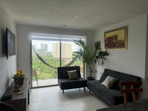 een woonkamer met een bank, een stoel en een raam bij Apto completo Bello horizonte in Playa Bello Horizonte