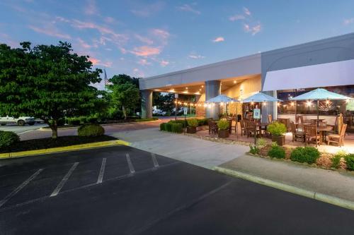 a parking lot in front of a building with tables and umbrellas at Clarion Inn Asheville Airport in Fletcher