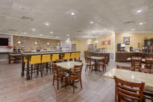 a restaurant with tables and chairs and a bar at Clarion Inn Asheville Airport in Fletcher