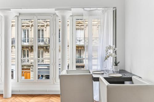 une pièce blanche avec une table, des chaises et une fenêtre dans l'établissement Jardin du Luxembourg I Central and Bright, à Paris