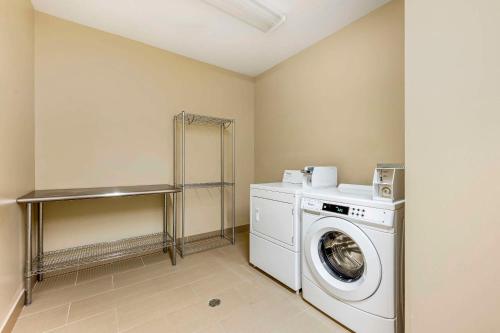 a laundry room with a washing machine and a washer at Comfort Suites East Lincoln - Mall Area in Lincoln