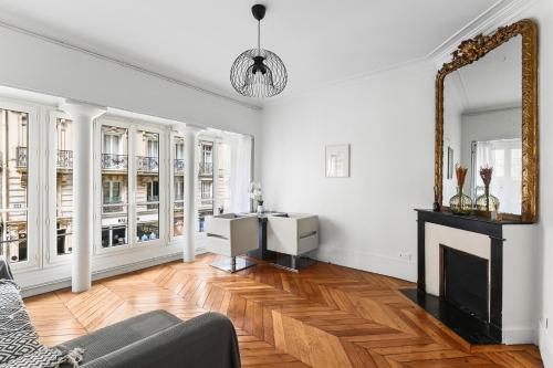un salon avec une cheminée et un miroir dans l'établissement Jardin du Luxembourg I Central and Bright, à Paris