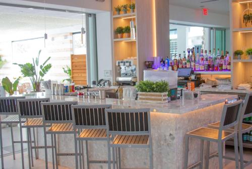 a bar with chairs and a counter in a restaurant at MB Hotel, Trademark Collection by Wyndham in Miami Beach