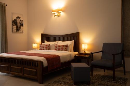a bedroom with a large bed and a chair at Naila Kothi - A Luxury Boutique Royal Suites in Jaipur in Jaipur