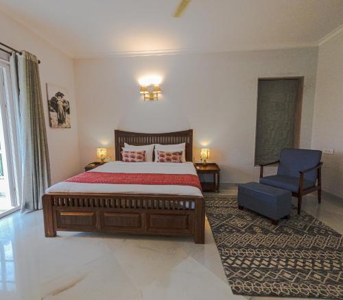 a bedroom with a large bed and a blue chair at Naila Kothi - A Luxury Boutique Royal Suites in Jaipur in Jaipur