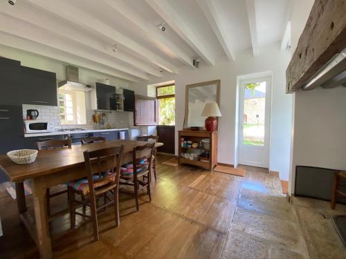 une cuisine et une salle à manger avec une table et des chaises dans l'établissement Jolie maison à la campagne, à Le Lonzac