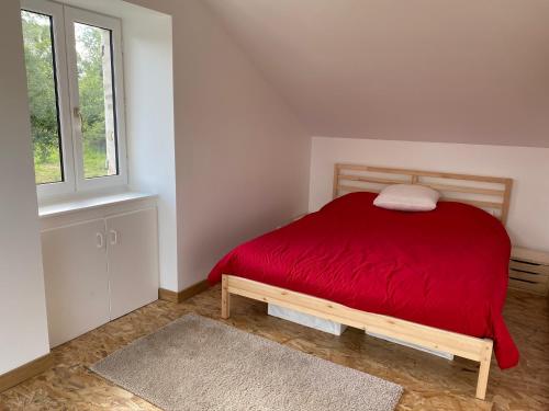 - une chambre avec un lit rouge et une fenêtre dans l'établissement Jolie maison à la campagne, à Le Lonzac
