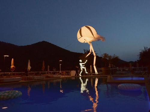 a statue of a person standing next to a pool at Mondrian Ibiza in Cala Llonga