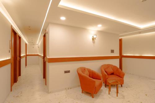 a hallway with two orange chairs in a room at Alokah Kashi in Varanasi