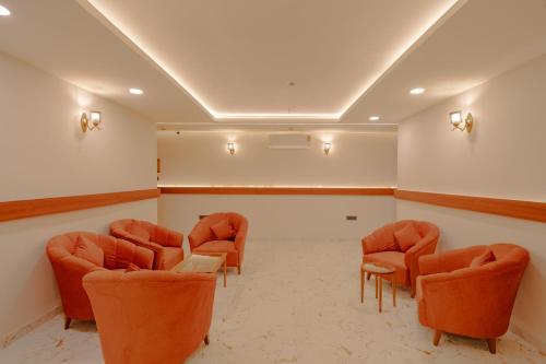 a waiting room with orange chairs and a screen at Alokah Kashi in Varanasi