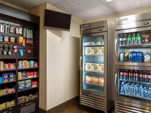 a refrigerator in a store with food and drinks at Wingate by Wyndham St Louis Airport in Saint Ann