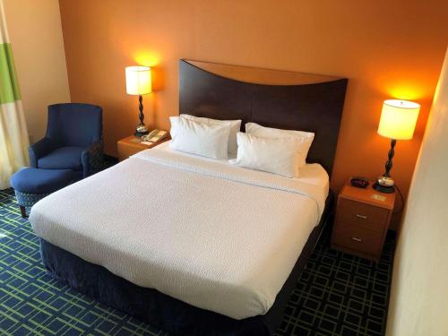 a bedroom with a large bed and a blue chair at Country Inn & Suites by Radisson, Fayetteville I-95, NC in Fayetteville
