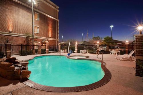 a swimming pool in front of a building at night at Country Inn & Suites by Radisson, College Station, TX in College Station