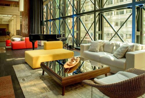 a living room with a couch and a piano at Radisson Montevideo Victoria Plaza Hotel in Montevideo