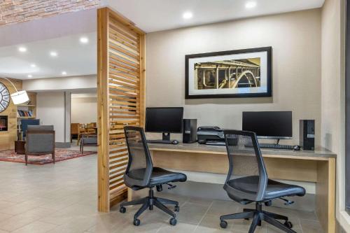 an office with two chairs and a desk with a computer at Country Inn & Suites by Radisson, Atlanta Airport South, GA in Atlanta