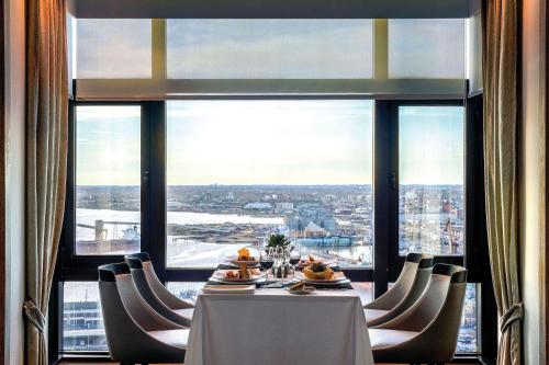 a dining room with a table and chairs and a large window at Radisson Montevideo Victoria Plaza Hotel in Montevideo