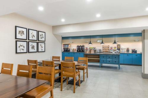 a dining room with blue cabinets and tables and chairs at Country Inn & Suites by Radisson, Atlanta Airport South, GA in Atlanta