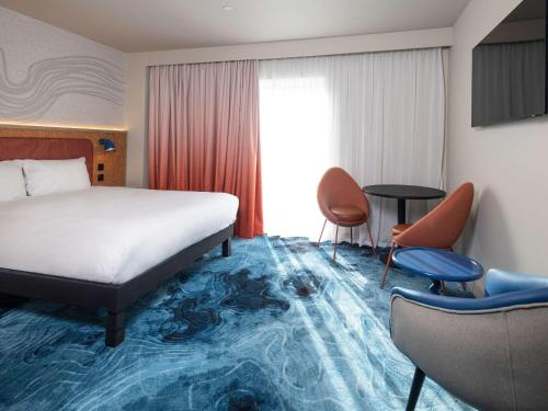 a hotel room with a bed and a table and chairs at ibis Styles Burton On Trent in Burton upon Trent