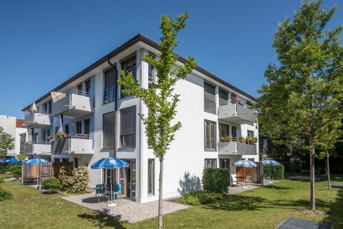 an apartment building with umbrellas in front of it at AMENITY-Garden-Apartments in Munich