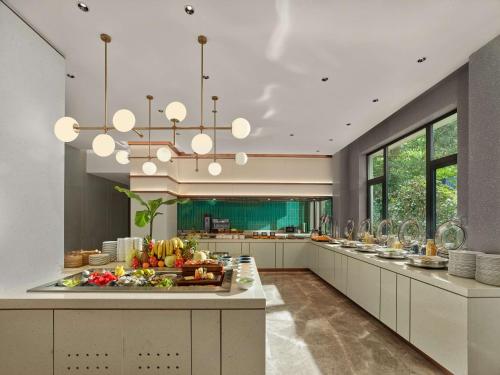 a large kitchen with a buffet of fruits and vegetables at Hilton Garden Inn Hangzhou West Lake in Hangzhou