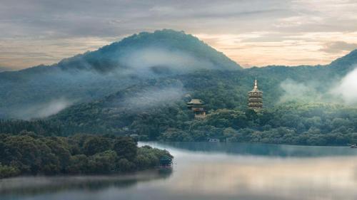 a view of a lake with a building in the middle at Hilton Garden Inn Hangzhou West Lake in Hangzhou