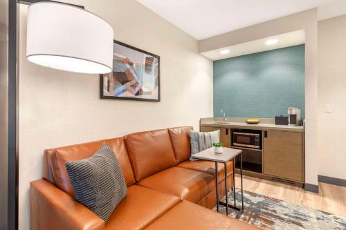 a living room with a couch and a kitchen at Cambria Hotel Denver Downtown RiNo in Denver