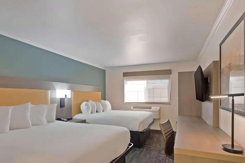 a hotel room with two beds and a television at Comfort Inn Hayward - Union City in Hayward